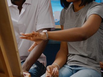 African american artists analyzing drawing of vase sitting in artwork studio room at home. Black young man and woman designing modern masterpiece working as team for fine art project